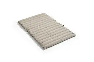 Beige, quiltet pude med vandrette syninger. Rektangulær form, blød og indbydende til afslapning.