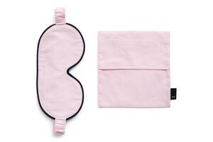 Blød pink sovemaske med sort kant og elastisk bånd, inkl. matchende opbevaringspose.