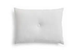 Lys grå pude i rektangulær form med en knap i midten, glat stof og moderne design.