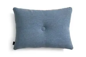 Rektangulær himmelblå pude med tekstur og central knap. Mærketag fra Hay på siden.