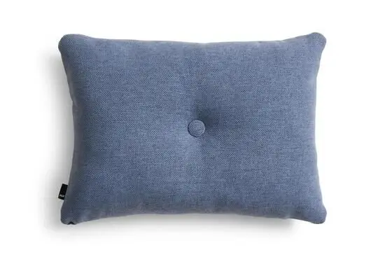 Rektangulær violet pude med tekstur, central knap, afrundede hjørner og mærke på siden.