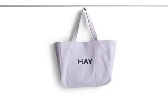 Medium lavendel shopper taske fra HAY med to håndtag og mørkt tryk på siden.