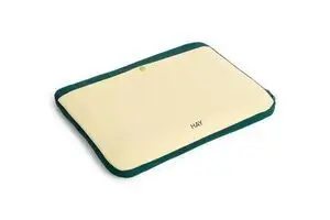 Blødt gult laptop-cover med mørkegrøn kant, til 13"/14" laptops. "HAY" logo nederst.