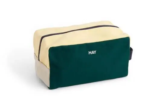 Mørkegrøn vaskepose fra Hay med lys gul top og lynlås. "HAY" står på forsiden.