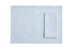 Rektangulær dug i blød blå med en foldet serviet ovenpå. Del af et sæt med 4 enheder.