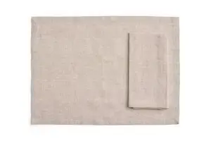Sæt af fire rektangulære servietter/duge i blød beige, en serviet ovenpå dugen.