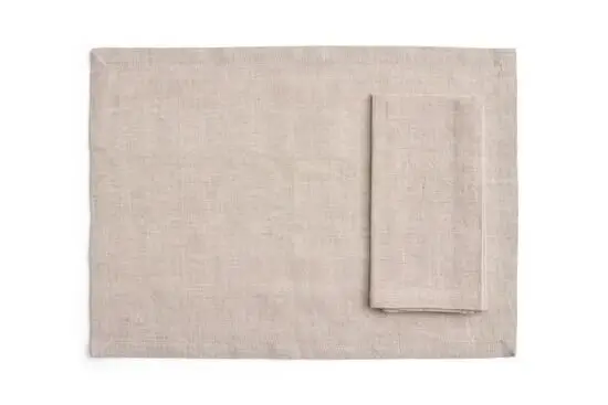 Sæt af fire rektangulære servietter/duge i blød beige, en serviet ovenpå dugen.