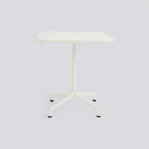 En kvadratisk, cremefarvet aluminiumsbord med central ben og fire fødder. Moderne og minimalistisk design.