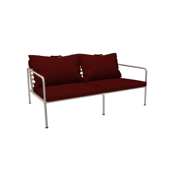 To-personers sofa med skarlagenrøde puder og hvidt stel.