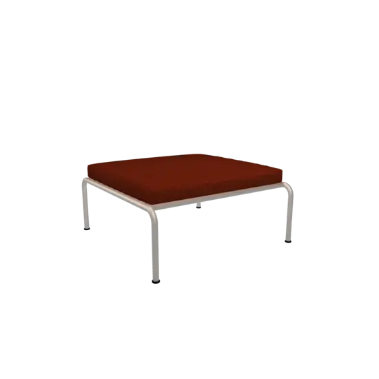 Firkantet ottoman med rustfarvet pude og muted hvid stel, designet i en minimalistisk stil.
