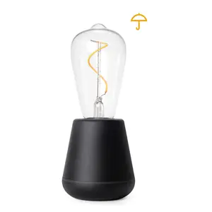 Sort udendørs bordlampe med spiralpære og klar glaskuppel. Paraplyikon til stede.