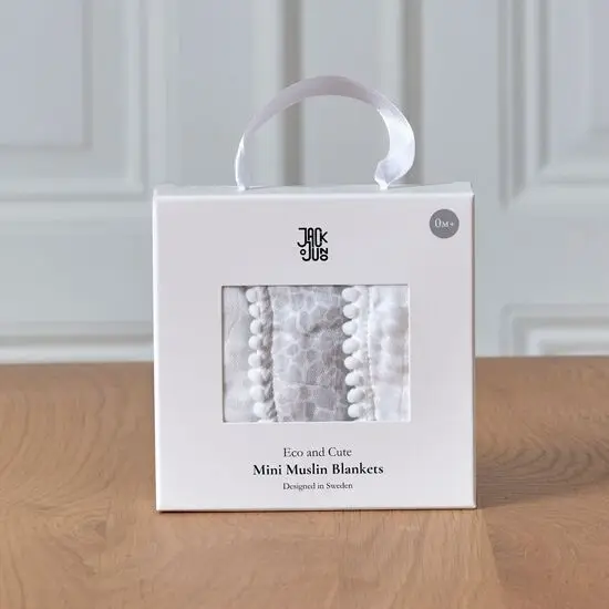 Pakke med hvide mini muslin tæpper med kant, i en rektangulær æske med bærehåndtag.