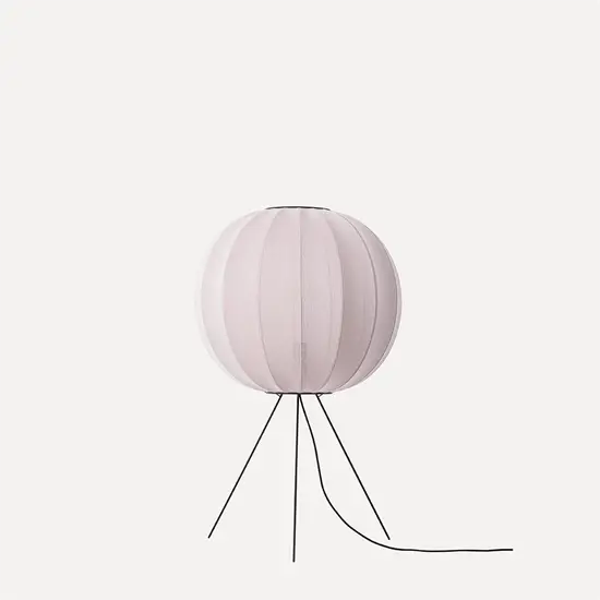 Rund gulvlampe med lyserød stofskærm og minimalistisk design på sort stativ.