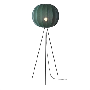 Gulvlampe med rund, ribbet, dybgrøn skygge og tynde ben.