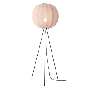 Gulvlampe med rund, lys skygge og tre sorte ben i metal, skaber et moderne og minimalistisk udtryk.