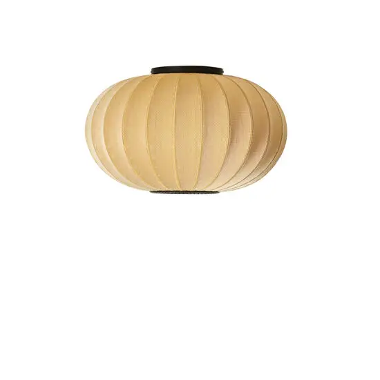 Oval lampe i solopgangsfarve med stoflignende tekstur til loft- eller vægmontering.
