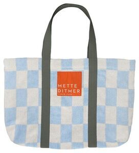 Strandtaske med lys blå/hvid tern, mørke håndtag og rød label med "METTE DITMER".