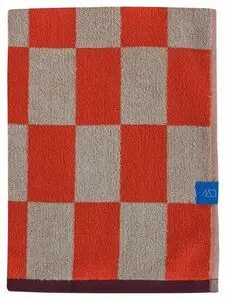 Badehåndklæde med mørk orange og beige skakmønster, blåt logo-mærke på højre side.