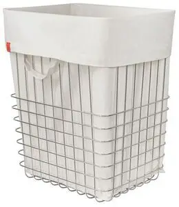 Stor krom trådkurv med hvid canvaspose og håndtag, lille orange mærke på posen.
