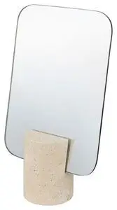 Rektangulært spejl med afrundede hjørner i en cylindrisk, tekstureret base i beige travertin.