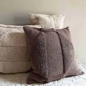 Brun pudebetræk med glat og fluffy tekstur, 50x50 cm, sammen med lyse puder på seng.