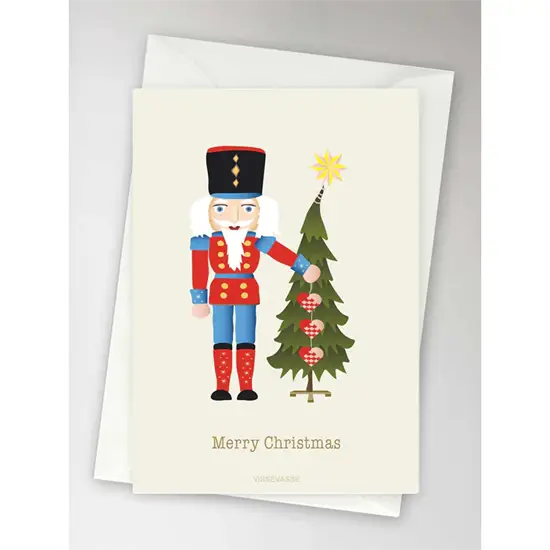 Julekort med nøddeknækker og juletræ, tekst "Merry Christmas", medfølgende hvid konvolut.