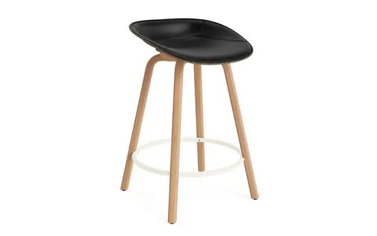Barstol med sort sæde, træben og minimalistisk design fra Normann Copenhagen.