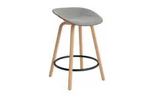 Barstol med buet sæde i søgrøn, lyse træben og sort fodstøtte, moderne design.