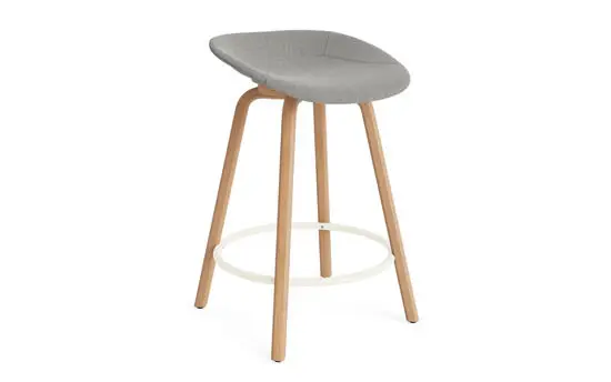 Barstol med creme polstret sæde, bøgeben og rund fodstøtte. Minimalistisk design.
