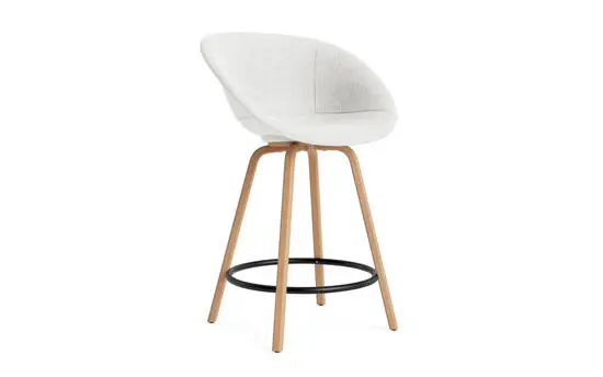 Hvid polstret barstol med begeben, buede ben og sort fodstøtte fra Normann Copenhagen.