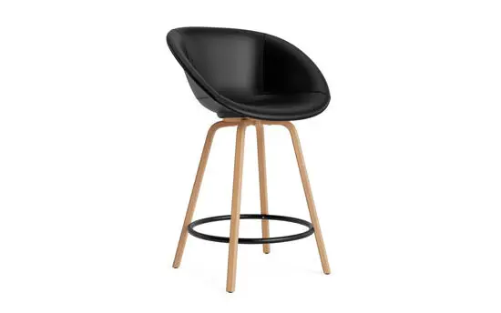 Sort polstret barstol med rund fodstøtte og ben i lyst træ. Moderne og elegant design.