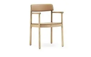 Minimalistisk armstol med polstret ryg og sæde, integrerede armlæn og moderne design fra Normann Copenhagen.