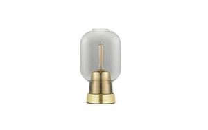 Bordlampe med gennemsigtig glasskærm og messinglignende base, som fremhæver pæren indeni.