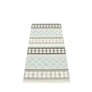 Tæppe med symmetriske striber og geometriske mønstre i lyseblå, grå og hvid.