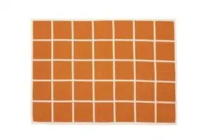 Rektangulært tæppe med bleg orange kvadrater og hvide linjer i et ensartet ternet mønster.