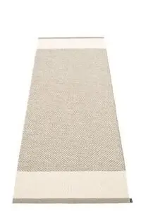 Rektangulært tæppe med mønstret overflade i mudder og vanilje nuancer, indrammet i mørkere toner.