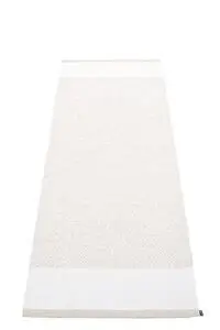 Rektangulært tæppe i fossil/hvid med mønster og synlig etiket i den ene ende.