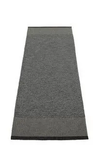 Rektangulært tæppe i sort, kul og granit nuancer med mørkere kant i begge ender.