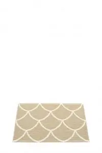 Rektangulært tæppe i sandfarve med lysere skæl-lignende mønster.