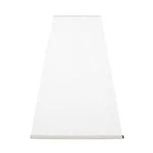 Rektangulært, ensfarvet hvidt tæppe med synlig kantdetalje, lidt mørkere eller mønstret kant.