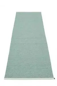 Rektangulært tæppe i lys jade med stribet struktur, lysere kanter og mærkat på siden.