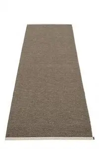 Langt, smalt tæppe i mørk brun med subtilt zigzag-mønster og lige kanter; mærkat ved enden.
