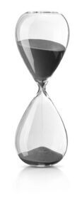 Gennemsigtigt timeglas med sort sand og smal hals, designet til en times tidsmåling.