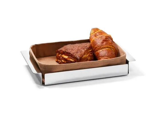 Rektangulær brødkurv med skinnende finish, stofindsats og to bagværk: croissant og wienerbrød.