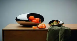 To skinnende, ovale frugtskåle; den ene med appelsiner, den anden med småkager.