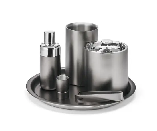 Sølvfarvet barware-sæt med shaker, isspand, tang og kop på rund bakke. Elegant, metallisk finish.
