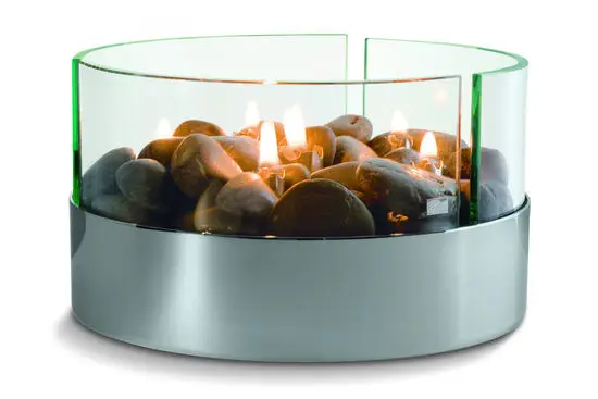 Rund olielampe med metalbase, glasindkapsling, flammer og dekorative sten.