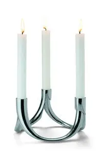 Tre moderne, buede lysestager med reflekterende overflade, hver med et højt lys.