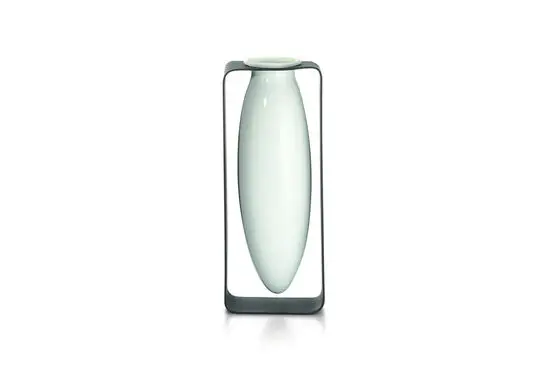 Slank, oval vase svæver i en rektangulær metalramme. Moderne og elegant design med rene linjer.