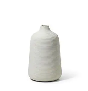 Høj vase med ribbet tekstur, lys farve og tilspidset form med bred bund og smal top.